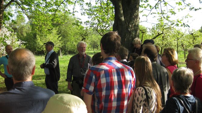 Menschen vor einem Baum und dem Vogelstimmenexperten